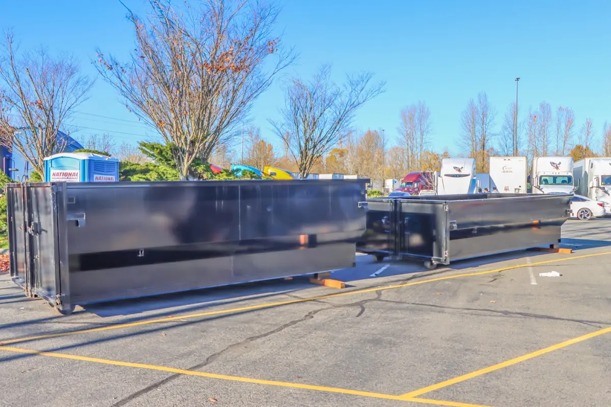 Professional dumpster rental service with roll-off container on residential driveway in Warren